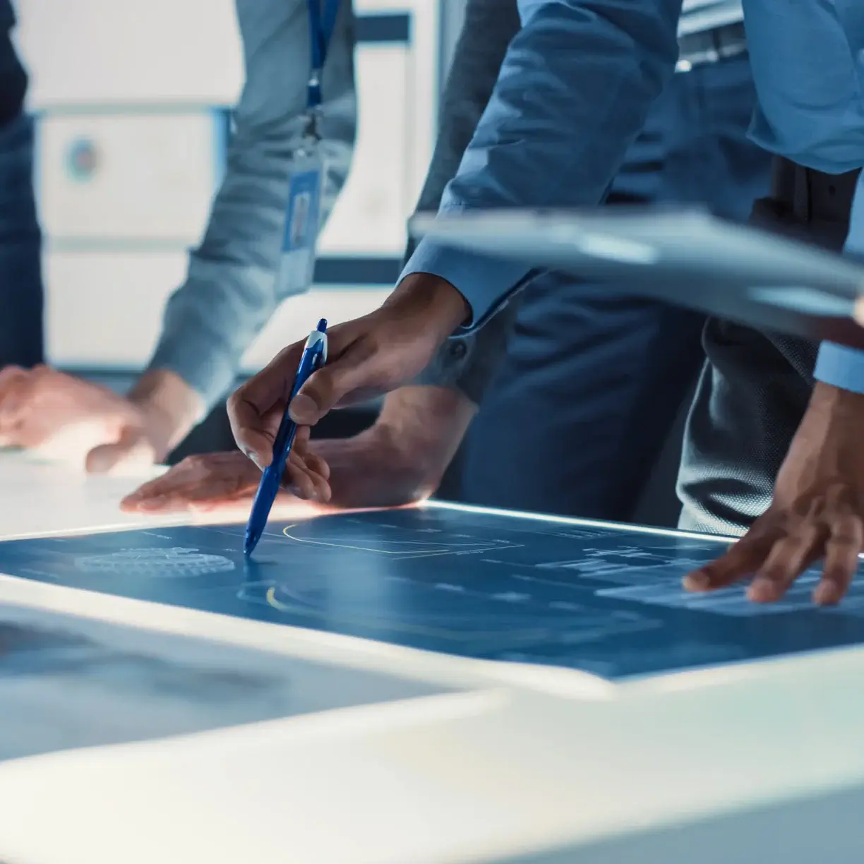 Surgeons and engineers reviewing a design on a digital table